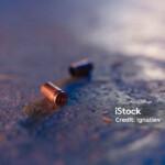 Two bullet casings on the floor in blue light in close up